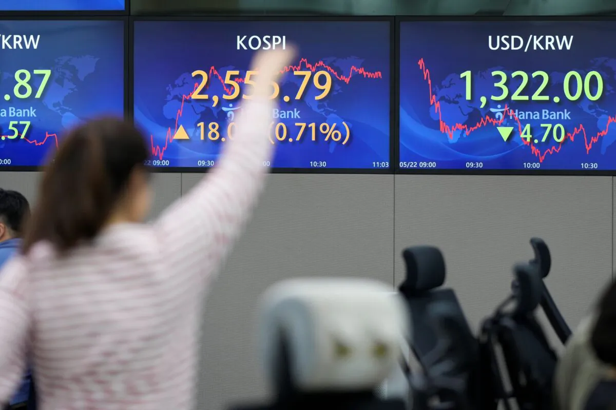 A currency stretches near the screens showing the Korea Composite Stock Price Index (KOSPI), (C), and the foreign exchange rate between U.S. dollar and South Korean won at a foreign exchange dealing room in Seoul, South Korea, on May 22, 2023. (Lee Jin-man/AP Photo)