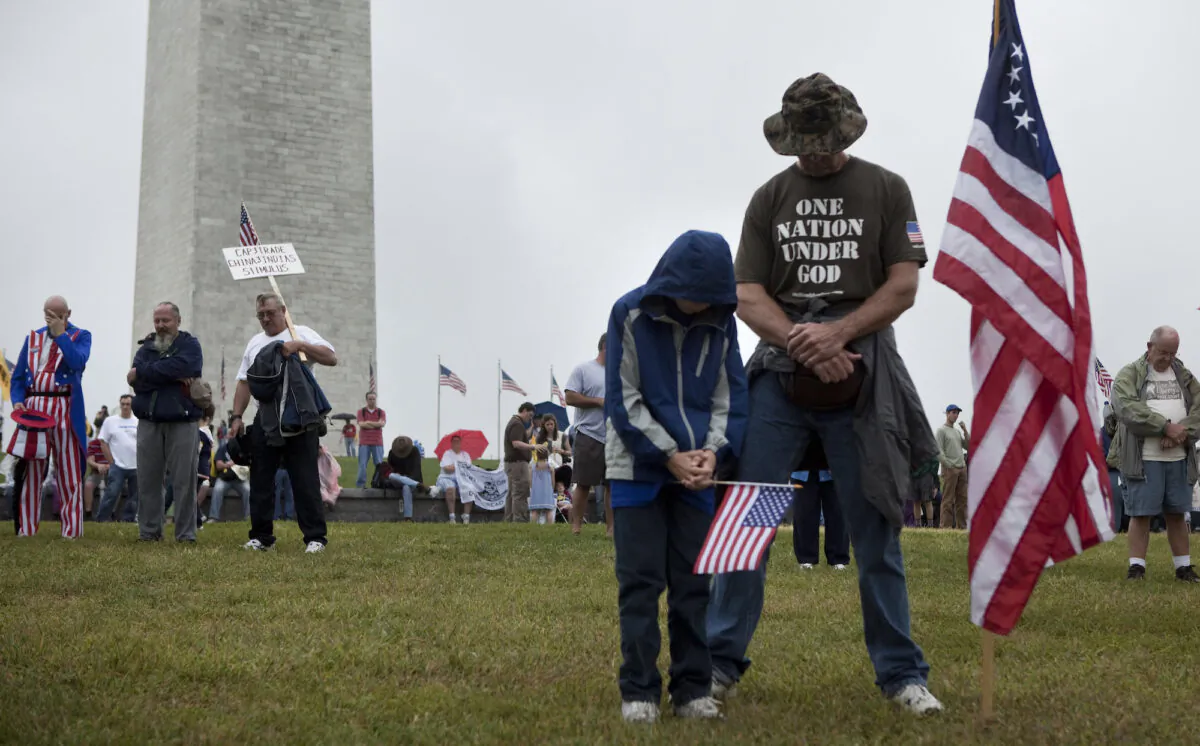 People bow their heads in prayer during a rally on the National Mall near the Washington Monument on Sept. 12, 2010 in Washington, D.C. (Brendan Smialowski/Getty Images)