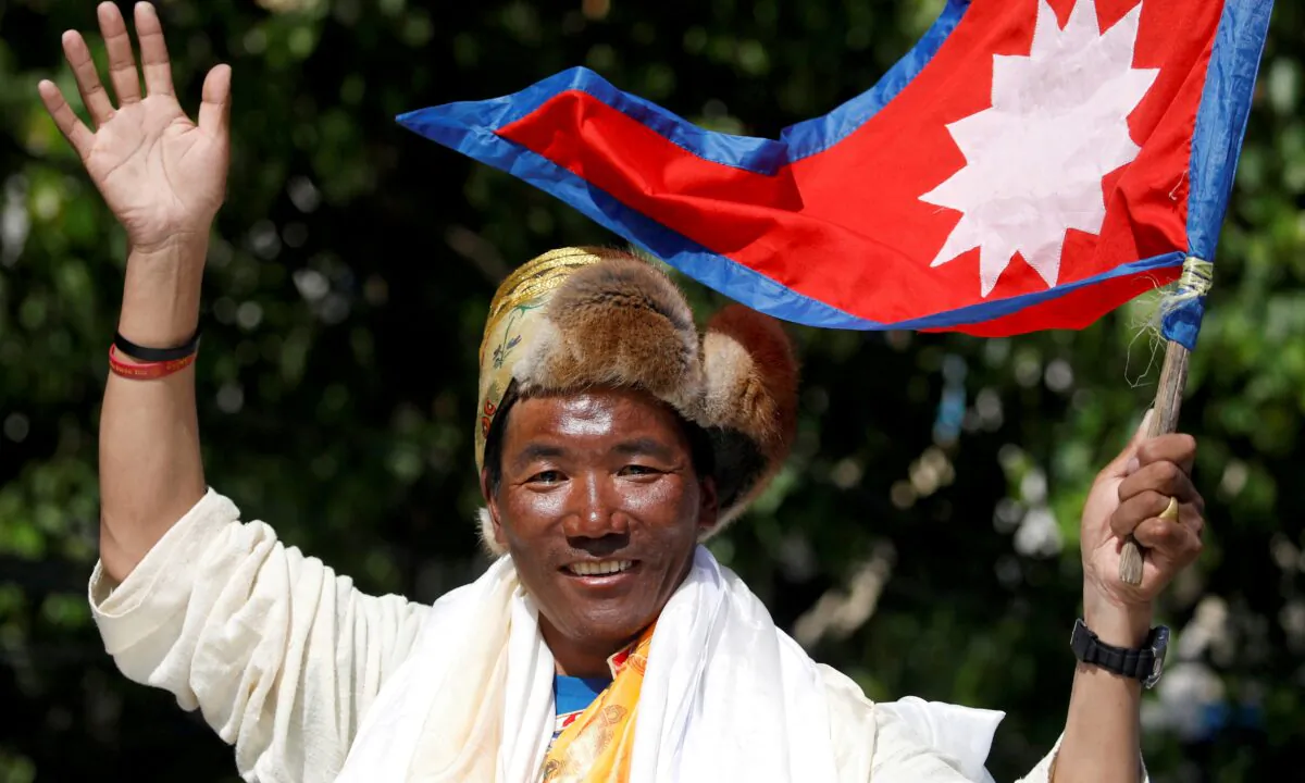 Nepali mountaineer Kami Rita Sherpa waves upon his arrival after climbing Mount Everest for the 24th time in 2019, setting a record for the most summits of the world's highest mountain, in Kathmandu, Nepal, on May 25, 2019. (Navesh Chitrakar/Reuters)