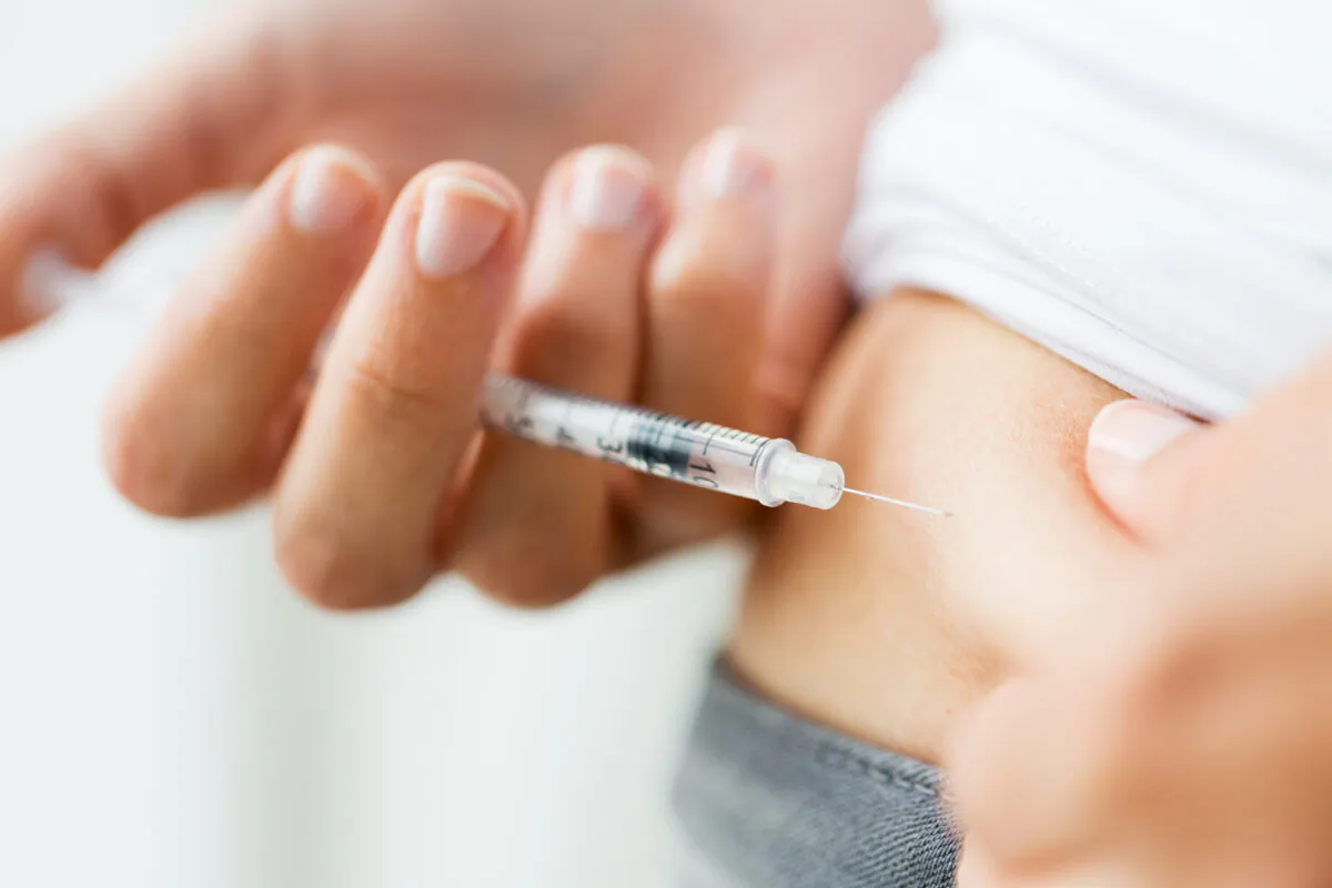 A woman with diabetes gives herself an insulin injection. (ShutterStock)