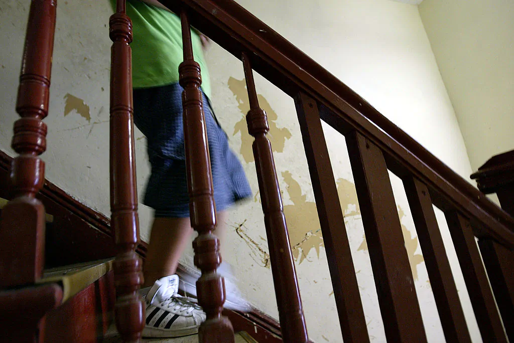 Children that have high levels of lead in their blood walk past a peeling lead paint wall in their apartment in the Brooklyn borough of New York City on July 25, 2003. (Spencer Platt/Getty Images)