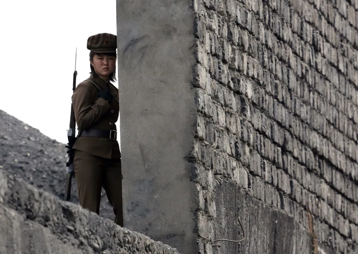 A North Korea woman soldier patrols the bank of the Yalu River which separates the North Korean town of Sinuiju from the Chinese border town of Dandong, northeast China's Liaoning province on April 26, 2014. (STR/AFP via Getty Images)