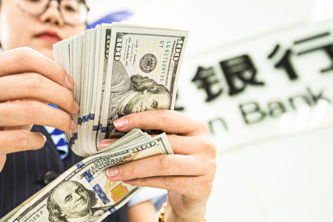 A Chinese bank employee counts US dollar bills at a bank counter in Nantong, Jiangsu Province, China, on Aug. 6, 2019. (STR/AFP via Getty Images)