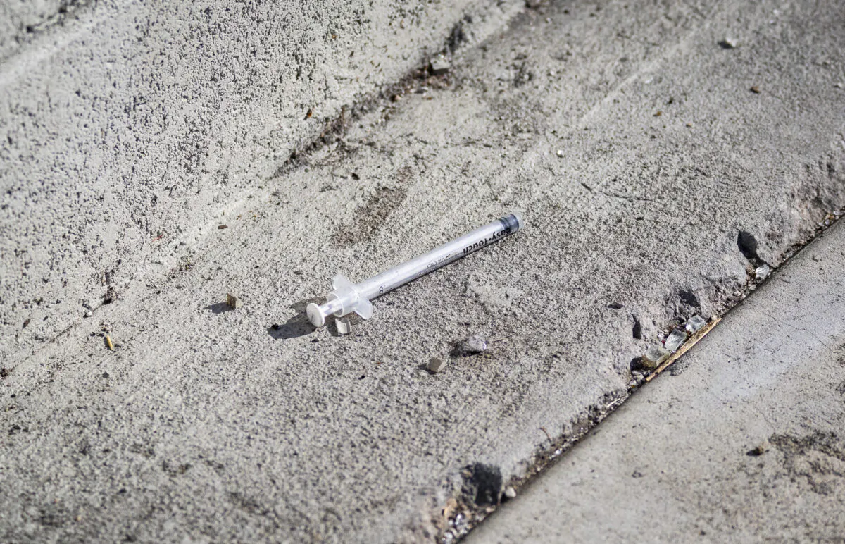 A used syringe lays discarded on a sidewalk outside of downtown Los Angeles on Jan. 21, 2022. (John Fredricks/The Epoch Times)