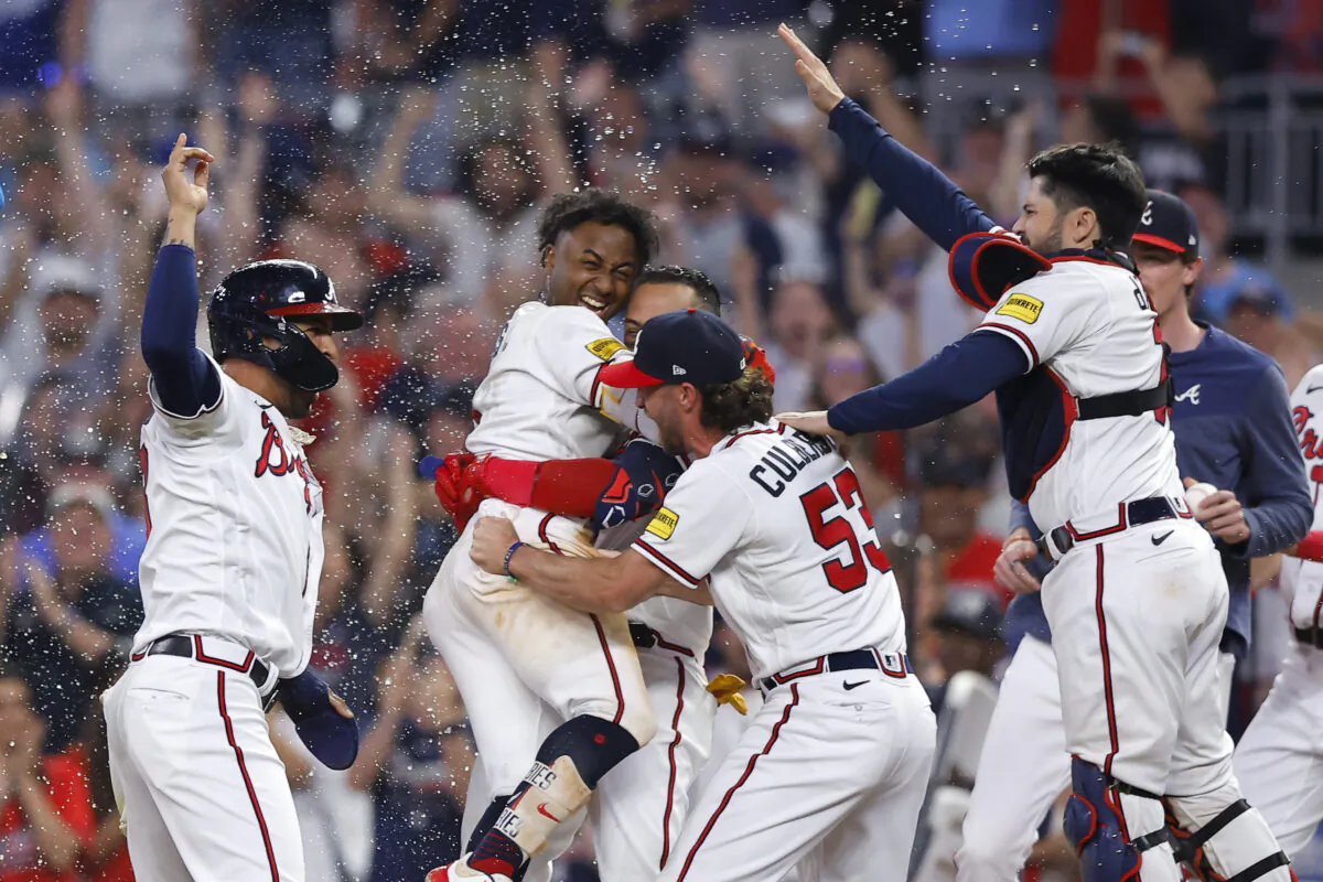 Ozzie Albies (1) of the Atlanta Braves celebrates with teammates after his sacrifice fly to with the game during the ninth inning against the Los Angeles Dodgers at Truist Park in Atlanta on May 24, 2023. (Todd Kirkland/Getty Images)