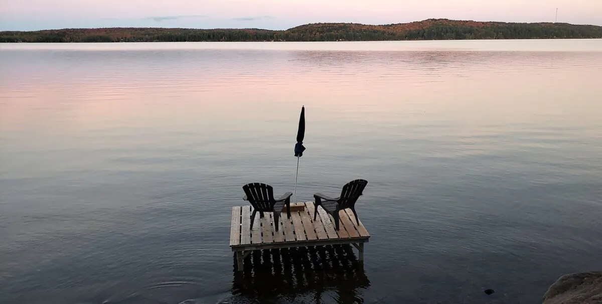 Muskoka chairs sit on a dock looking over Boshkung Lake, in Algonquin Highlands, Ont., on Oct. 5, 2020. (The Canadian Press/Giordano Ciampini)