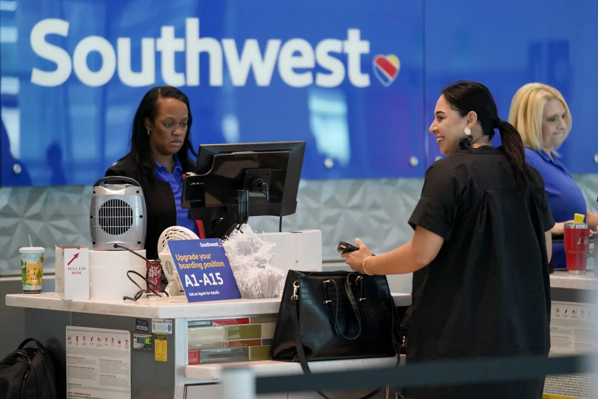 A Southwest airlines customer service representative (L) assists a traveler at the ticketing counter at Love Field airport in Dallas on May 19, 2023. (Tony Gutierrez/AP Photo)