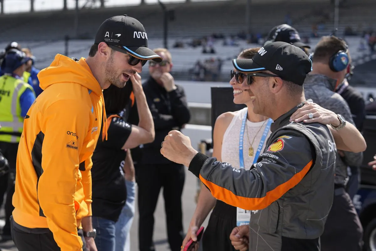 Alexander Rossi (L) talks with Tony Kanaan of Brazil and his wife Lauren Bohlander during qualifications for the Indianapolis 500 auto race at Indianapolis Motor Speedway in Indianapolis on May 20, 2023. (Darron Cummings/AP Photo)