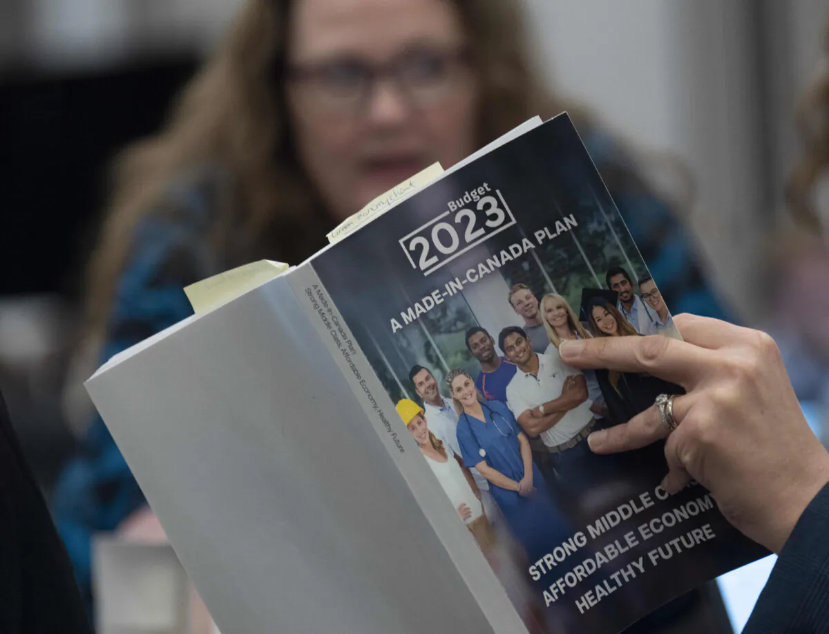 A reporter reads a copy of the Federal Budget in the lockup for the Federal budget, Tuesday, March 28, 2023 in Ottawa. THE CANADIAN PRESS/Adrian Wyld