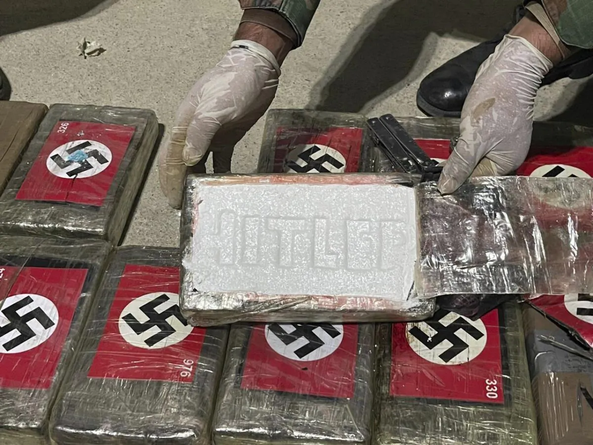 An officer shows blocks of cocaine marked with Nazi swastikas and stamped with the name "HITLER", at the port of Paita, Piura region, Peru, on May 25, 2023. (Peruvian Anti-Drug Police via AP)