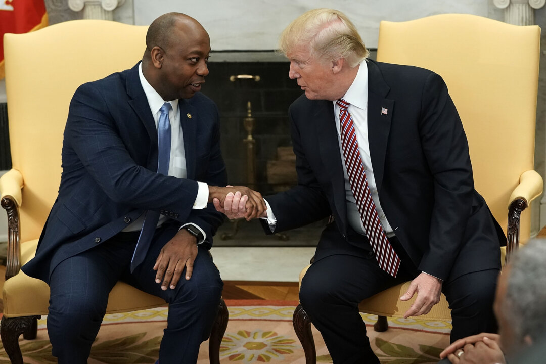 U.S. President Donald Trump shakes hands with Sen. Tim Scott (R-S.C.) during a working session regarding the Opportunity Zones provided by tax reform in the Oval Office on Feb. 14, 2018. (Alex Wong/Getty Images)