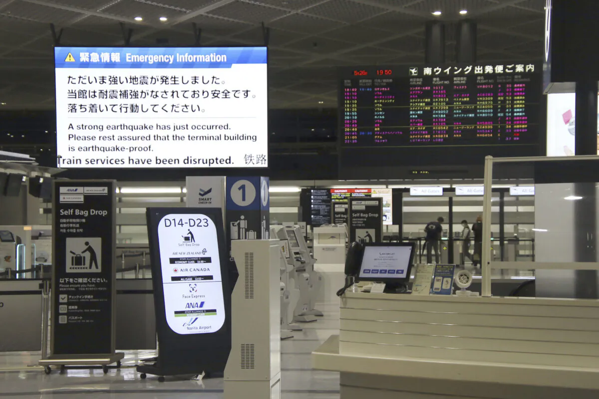 An electronic message board (upper L) at Narita International Airport in Narita, east of Tokyo, shows notice of an earthquake that occurred on May 26, 2023. (Kyodo News via AP)
