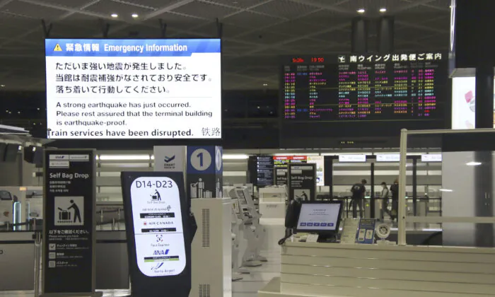 An electronic message board (upper L) at Narita International Airport in Narita, east of Tokyo, shows notice of an earthquake that occurred on May 26, 2023. (Kyodo News via AP)