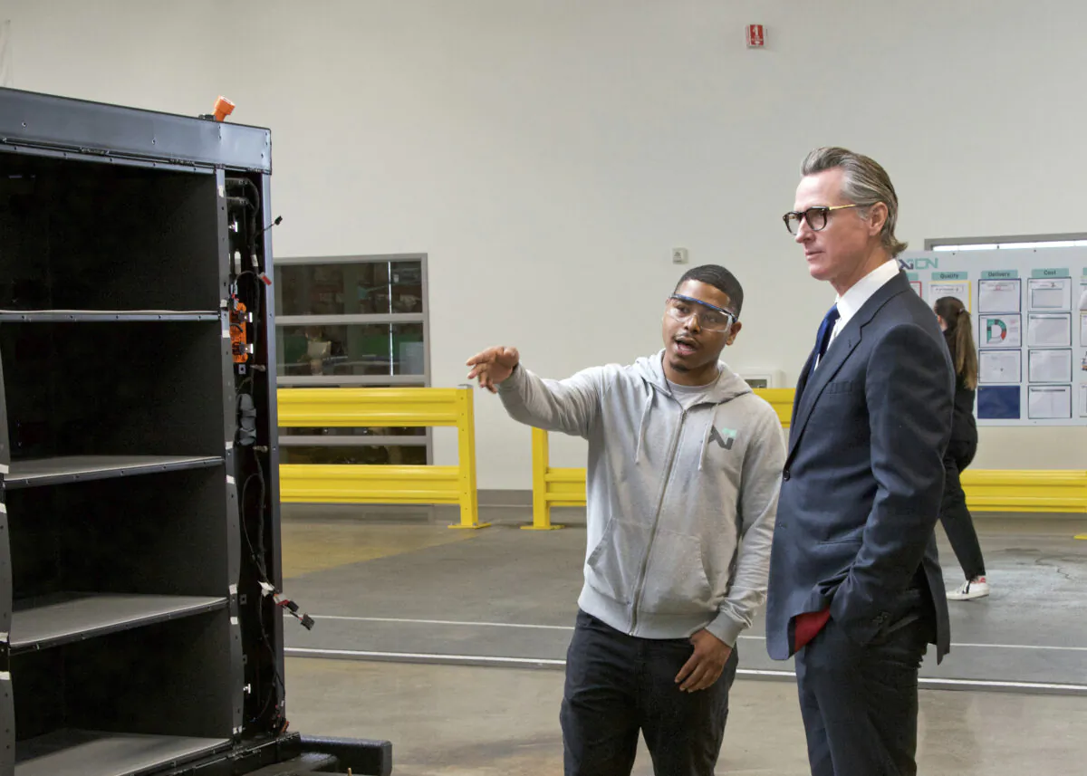 In this photo provided by the California Governor's Office, Gov. Gavin Newsom (R) talks to a MOXION employee in Richmond, Calif., on May 25, 2023. (Sheila Fitzgerald/California Governor's Office via AP)