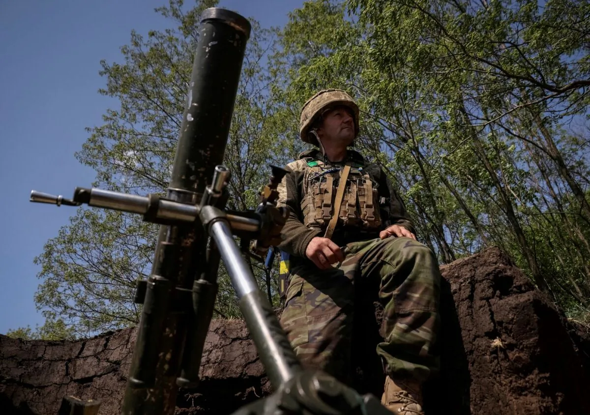 A Ukrainian service member prepares to fire a mortar at his positions at a front line near the city of Bakhmut in Donetsk region, Ukraine, on May 18, 2023. (Sofiia Gatilova/Reuters)