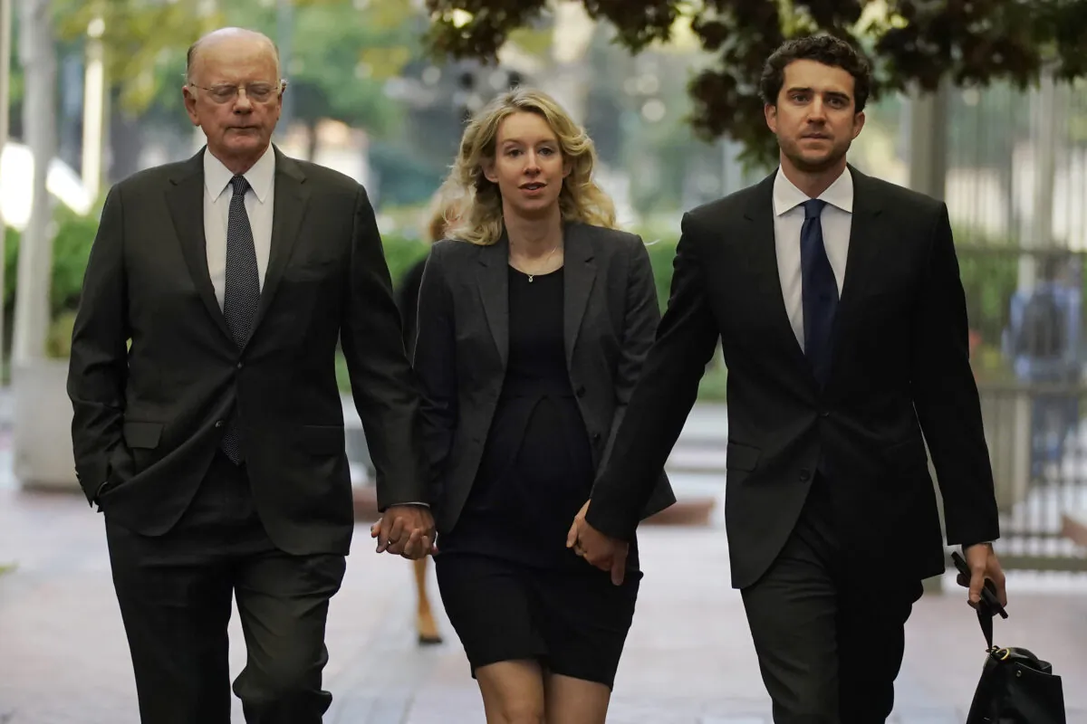 Former Theranos CEO Elizabeth Holmes (C) arrives at federal court with her father, Christian Holmes IV (L) and partner, Billy Evans, in San Jose, Calif., on Oct. 17, 2022. (Jeff Chiu/AP Photo)