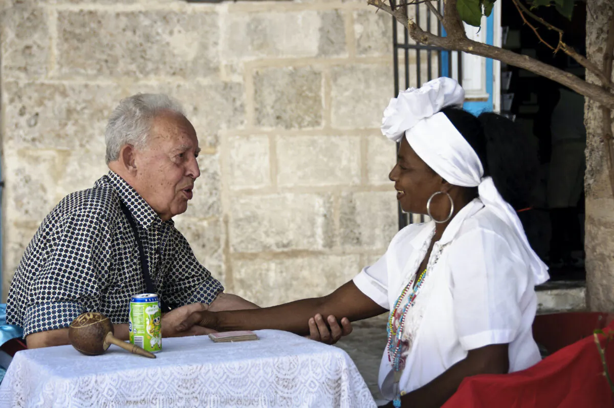 A Road Scholar tour participant interacts with a woman in Cuba. (Photo courtesy of Road Scholar.)