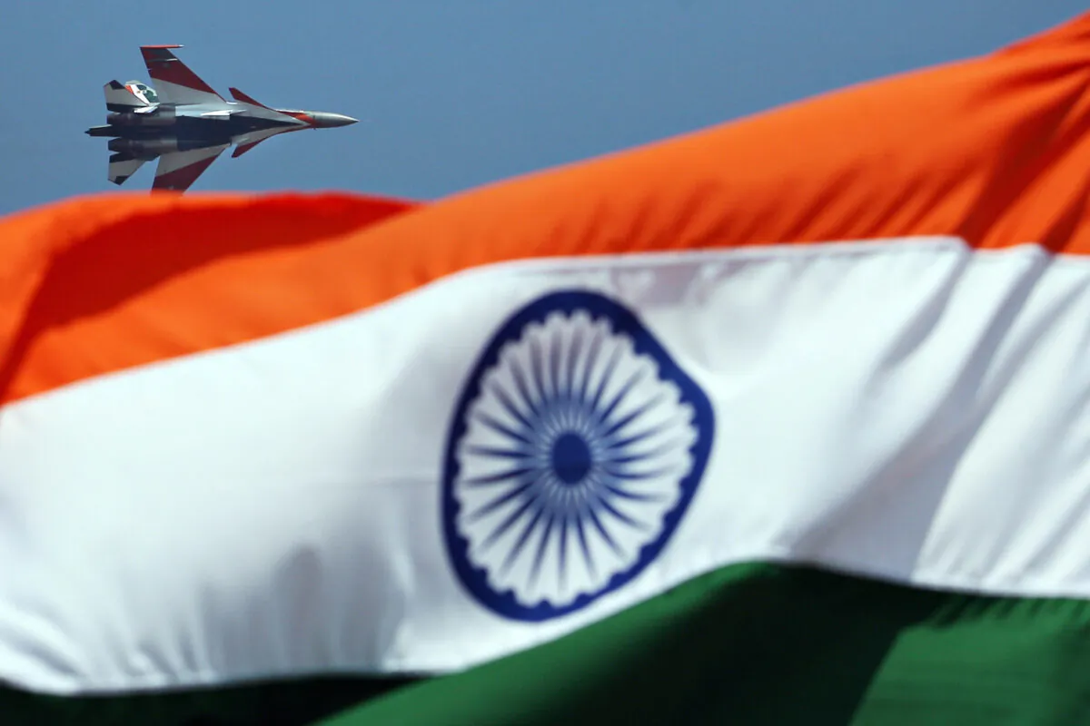An Indian Air Force Sukhoi Su-30 flies past an Indian national flag during the inauguration of Aero India 2009 at the Yelahanka Air Force Station in Bangalore, India, on Feb. 10, 2009. (Dibyangshu Sarkar/AFP via Getty Images)