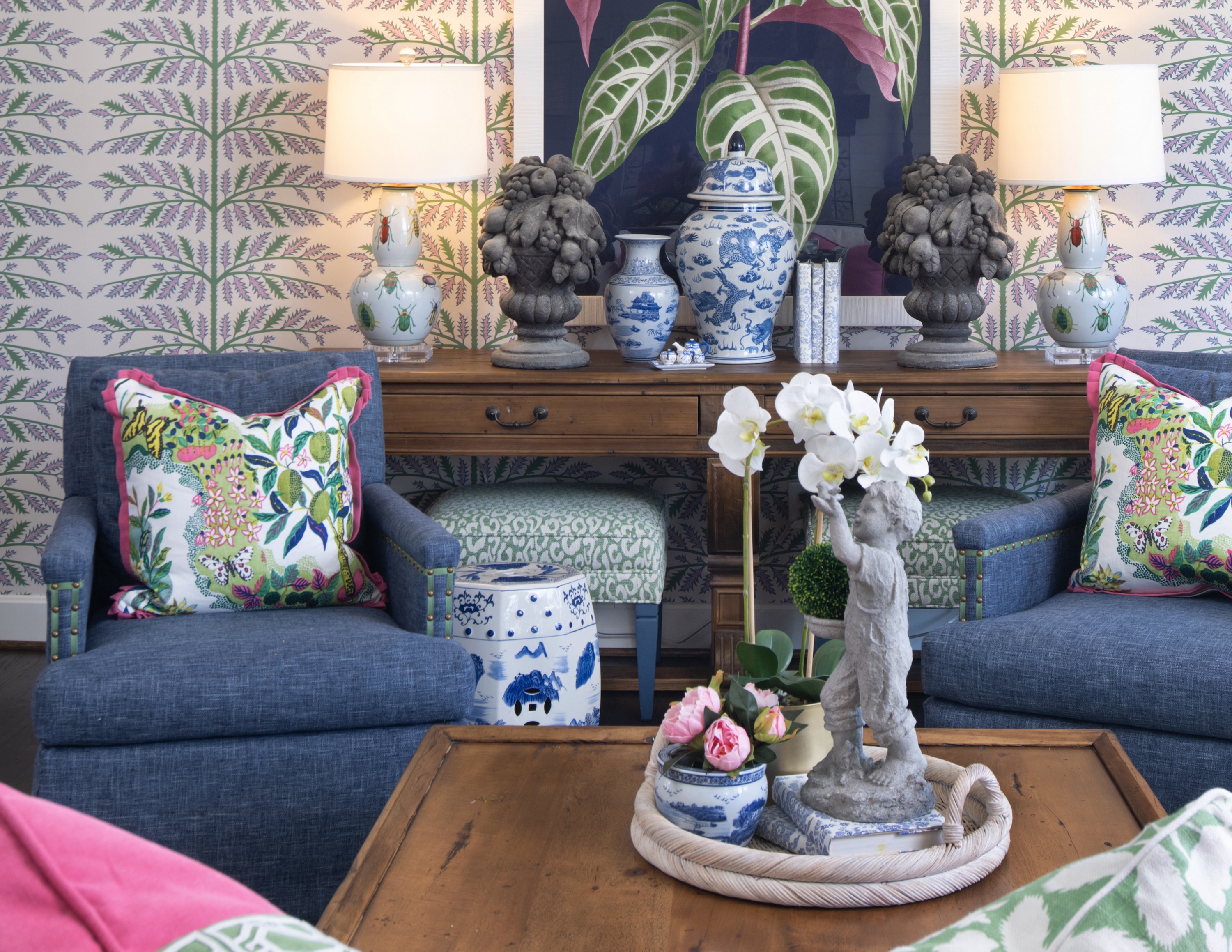 The living room walls are dressed up with a botanical-inspired Schumacher wallpaper in a cool and casual colorway.