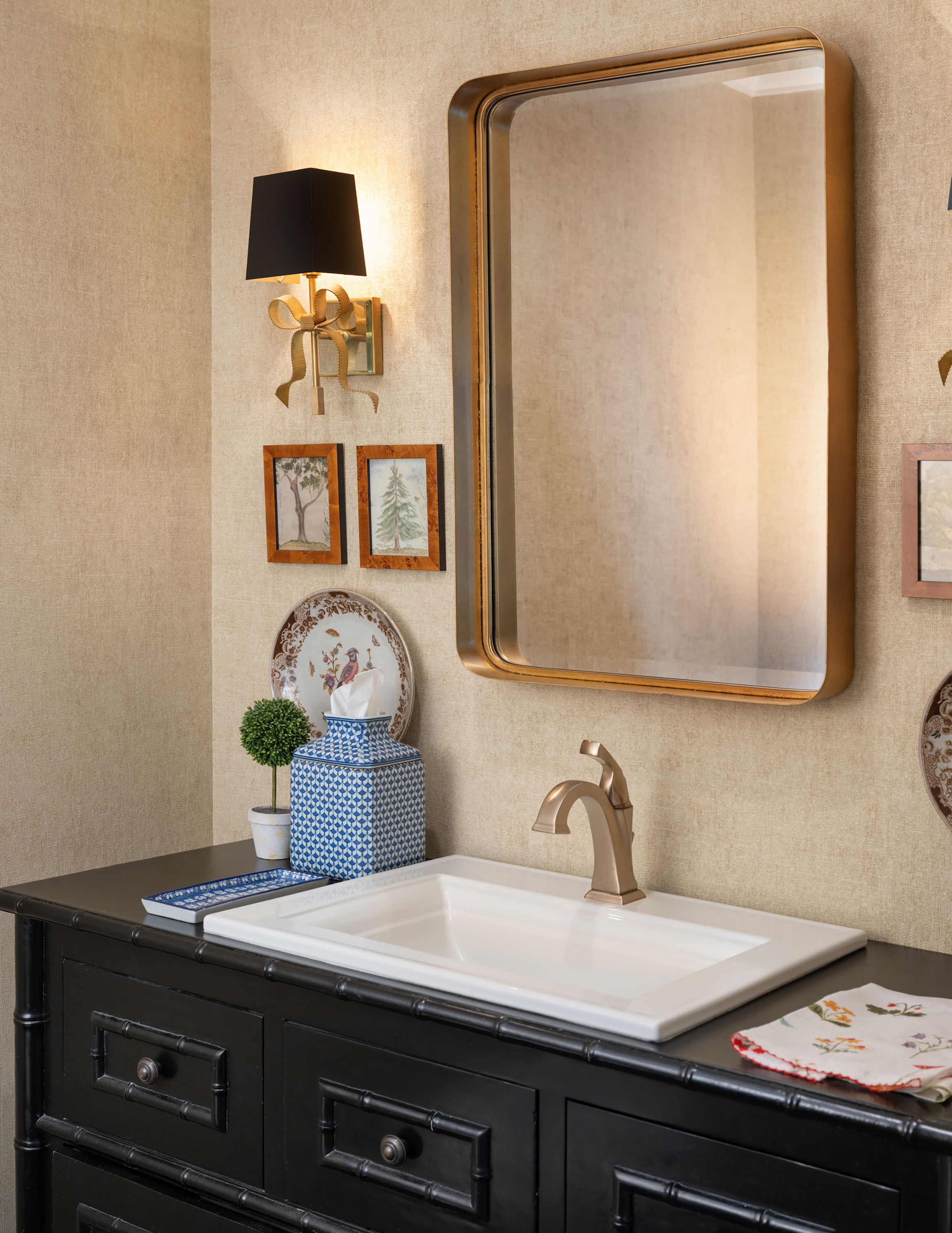 The powder room vanity, a chinoise-inspired piece with bamboo detailing, commands the space.