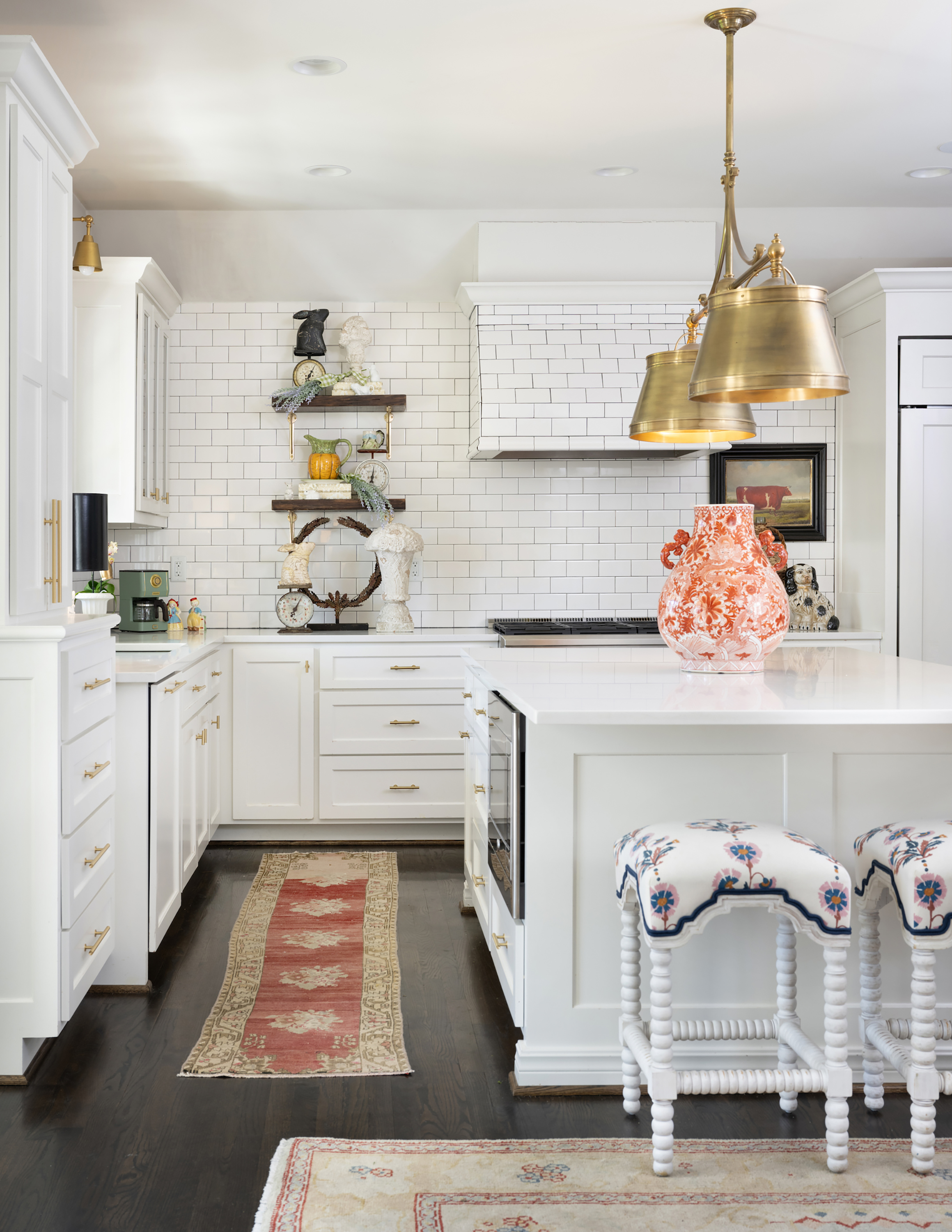 Anne lives for preppy chinoiserie, so a burnt orange vase makes perfect sense as the focal point of her kitchen island. Above it, she added brushed brass pendant lights.