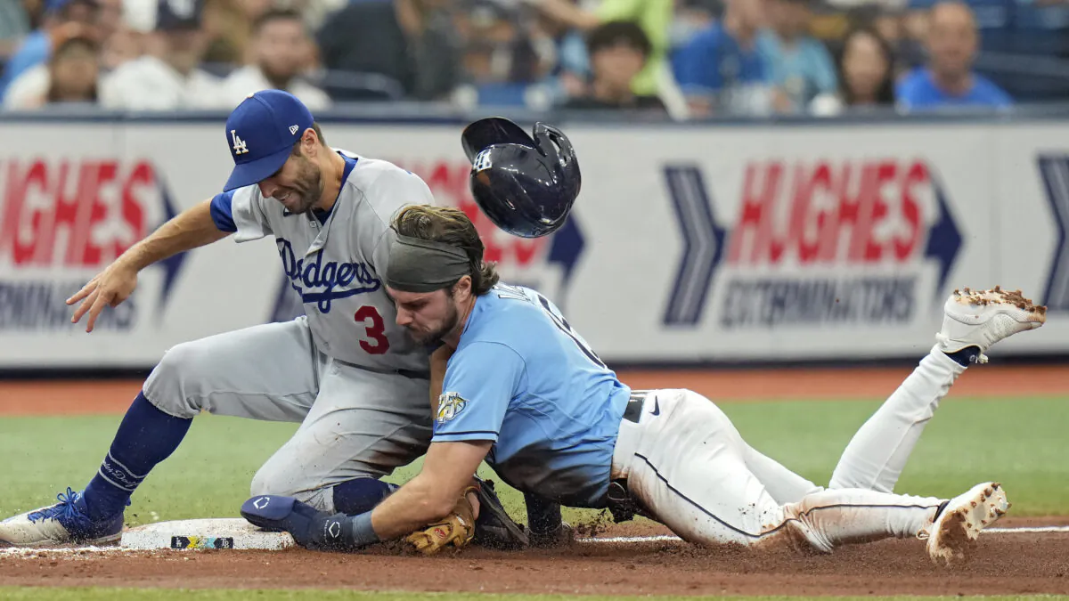 Tampa Bay Rays' Josh Lowe loses his helmet as he steals third base ahead of the tag by Los Angeles Dodgers' Chris Taylor (3) during the fourth inning of a baseball game in St. Petersburg, Fla., on May 28, 2023 (Chris O'Meara/AP Photo)