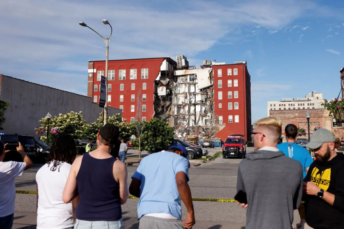 Onlookers watch as emergency crews work the scene of a partial building collapse on the 300 block of Main Street, in Davenport, Iowa on May 28, 2023. (Nikos Frazier/Quad City Times via AP)