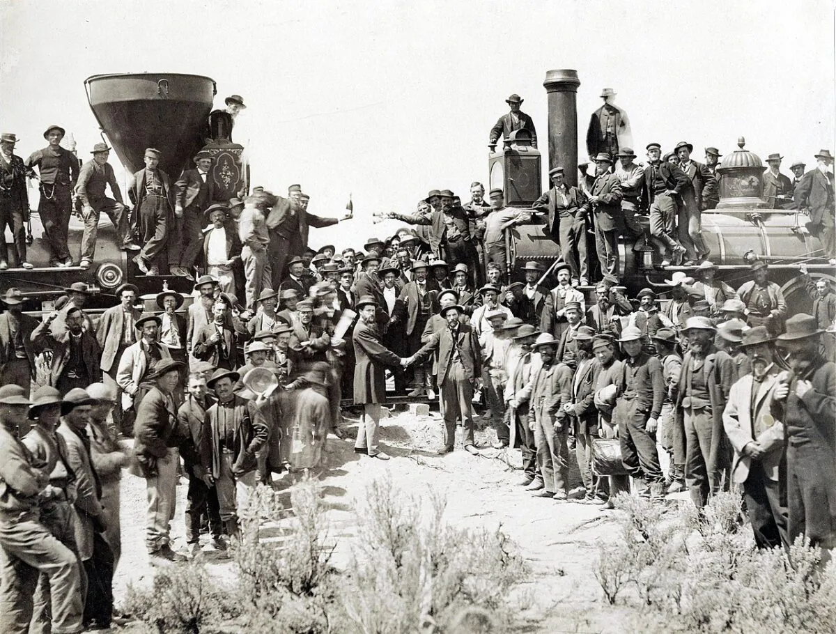 The ceremony for the driving of the golden spike at Promontory Summit, Utah, on May 10, 1869, by Andrew J. Russell. At center left, Samuel S. Montague, Central Pacific Railroad, shakes hands with Grenville M. Dodge, Union Pacific Railroad (center right). (Public Domain)