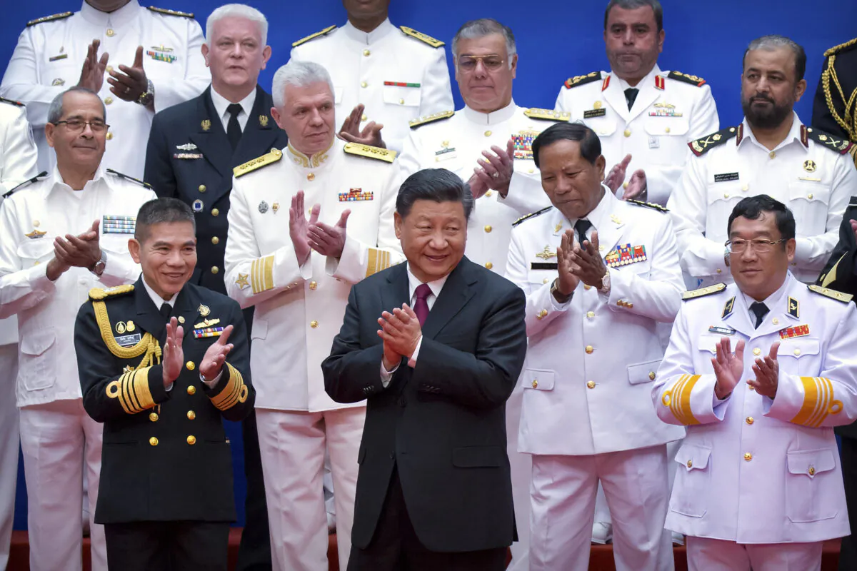 Chinese Communist Party leader Xi Jinping (front-C) and Chinese and foreign naval officials applaud after a group photo during an event to commemorate the 70th anniversary of the Chinese People's Liberation Army (PLA) Navy in Qingdao, in eastern China's Shandong province on April 23, 2019. (Mark Schiefelbein/AFP via Getty Images)