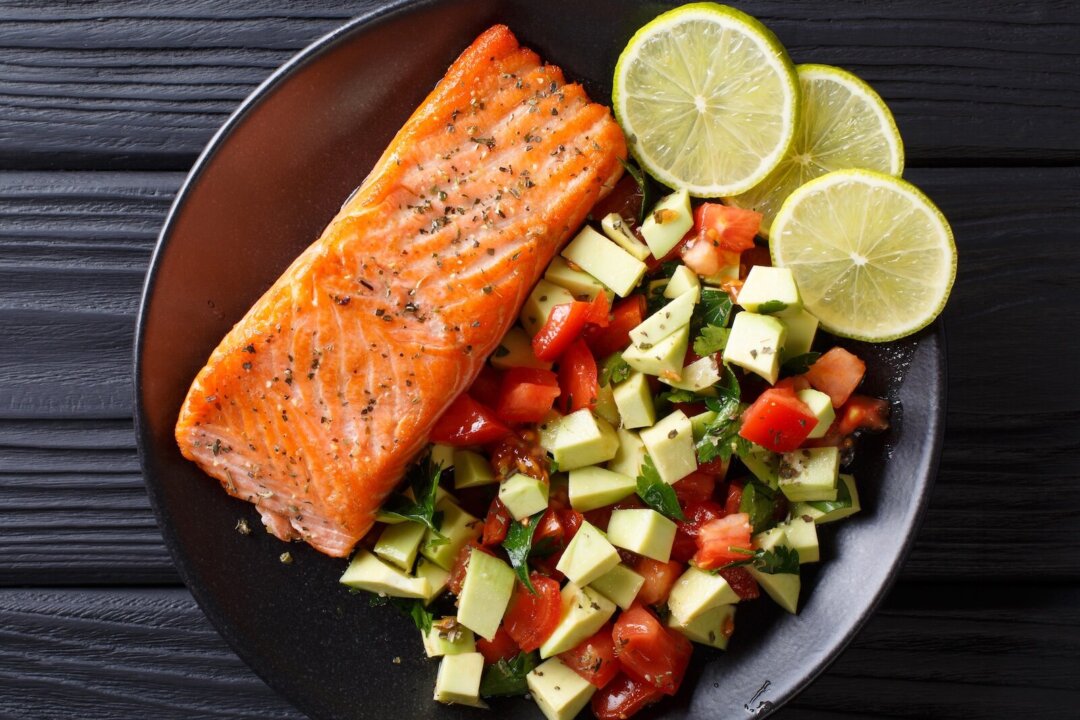 Fried salmon steak with avocado tomato salsa closeup on a plate. horizontal top view from above