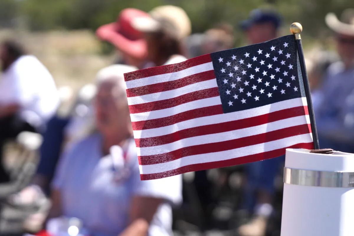 A small flag waves in the breeze during a Memorial Day ceremony in Ash Fork, Ariz., on May 29, 2023. (Allan Stein/The Epoch Times)