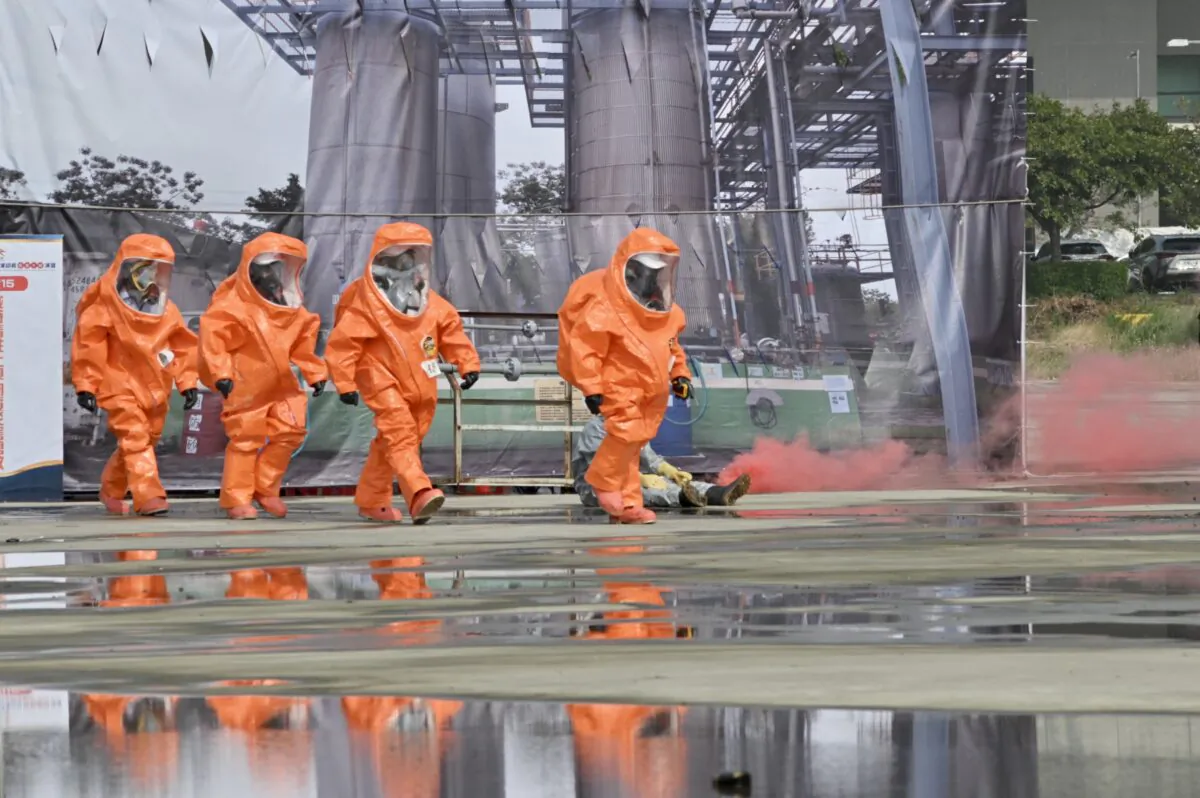 Rescuers in protective equipments walk past a mock collapsed nuclear power plant during a civilian drill while imitating a Chinese attack in Taichung, Taiwan, on April 13, 2023. (Sam Yeh/AFP via Getty Images)