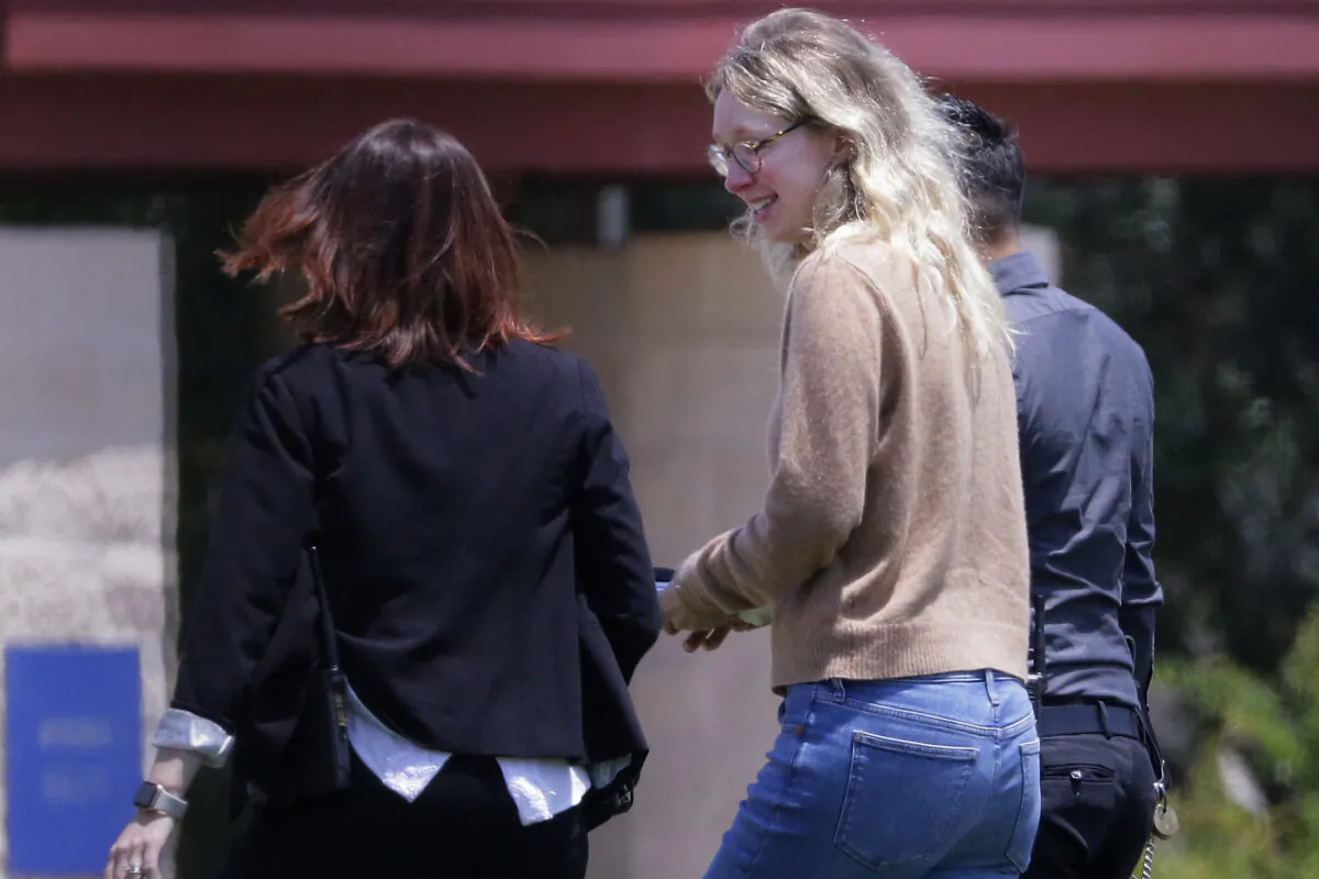 Disgraced Theranos CEO Elizabeth Holmes (C) is escorted by prison officials into a federal women’s prison camp on in Bryan, Texas, on May 30, 2023. (Michael Wyke/AP Photo)
