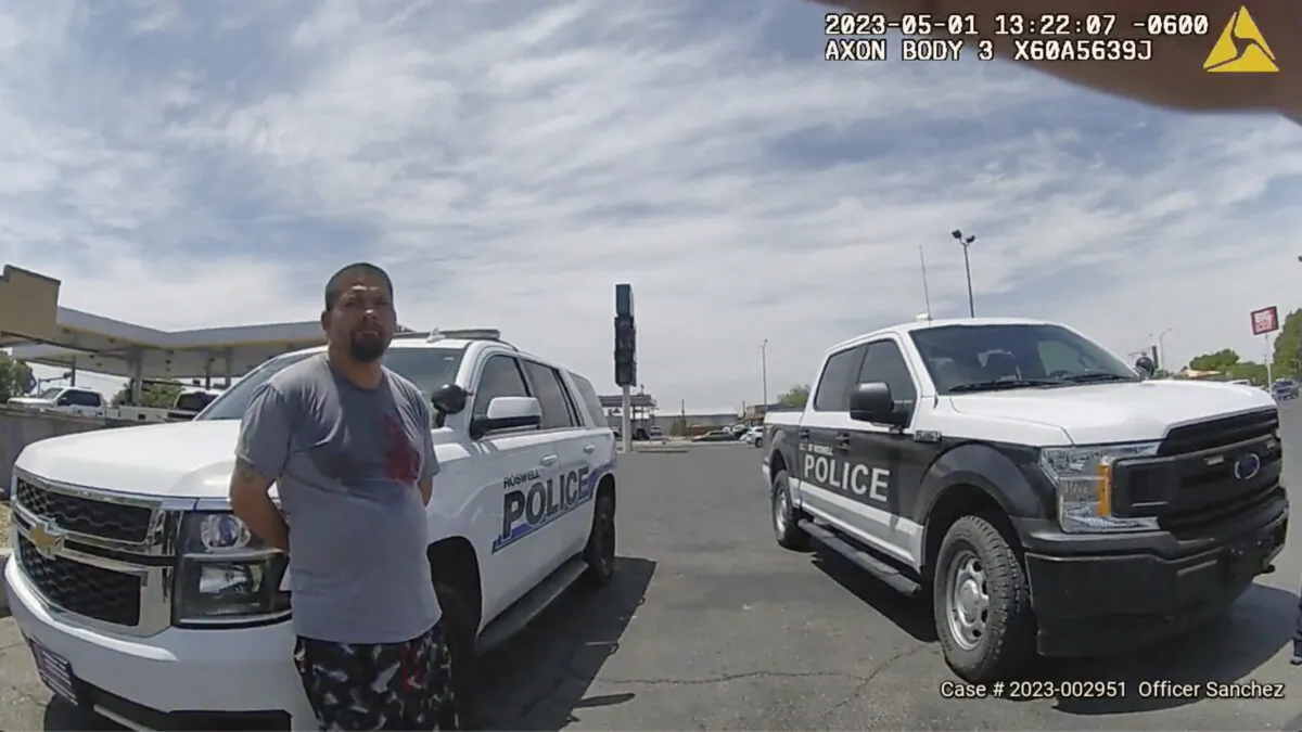 Tony Peralta leans against a police vehicle after turning himself in to authorities in Roswell, N.M., on May 1, 2023. (Roswell Police Department via AP)