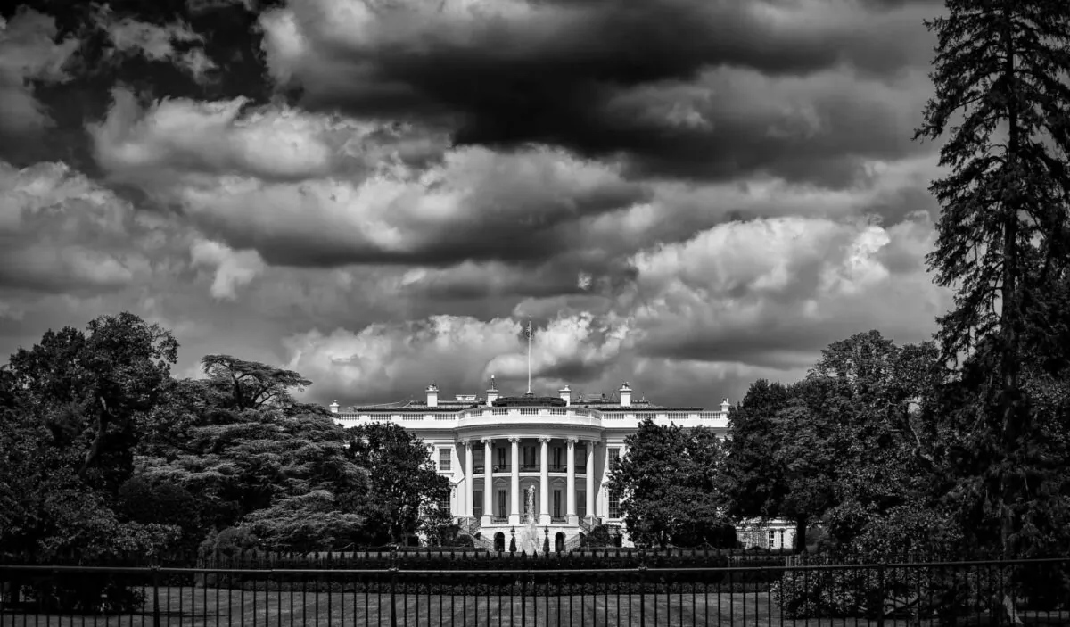 Dramatic black and white view of the White House, in Washington, D.C., with storm clouds brewing above it. (lazyllama/Shutterstock)