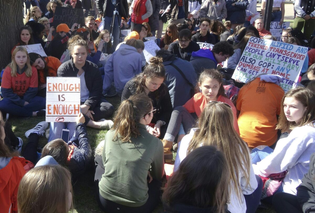 Students stage a sit-down in Lafayette Square across the White House in Washington, DC on April 20, 2018 to protest gun violence. - Students across the US were urged to walk out of classes to mark the 19th anniversary of the 1999 school shooting at Columbine High School in Colorado which left 13 people dead. The walkout has been organized by students at Marjory Stoneman Douglas High School in Parkland, Florida, where 14 students and three adult staff members were killed by a troubled former classmate on February 14, 2018. (Photo by Cyril JULIEN / AFP) (Photo credit should read CYRIL JULIEN/AFP via Getty Images)