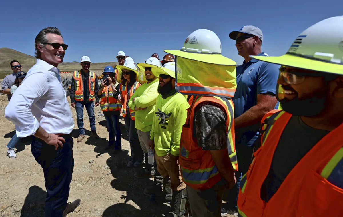 California Gov. Gavin Newsom talks with union electricians at Proxima Solar Farm outside Patterson, Calif., on May 19, 2023. (Andy Alfaro/The Modesto Bee via AP)