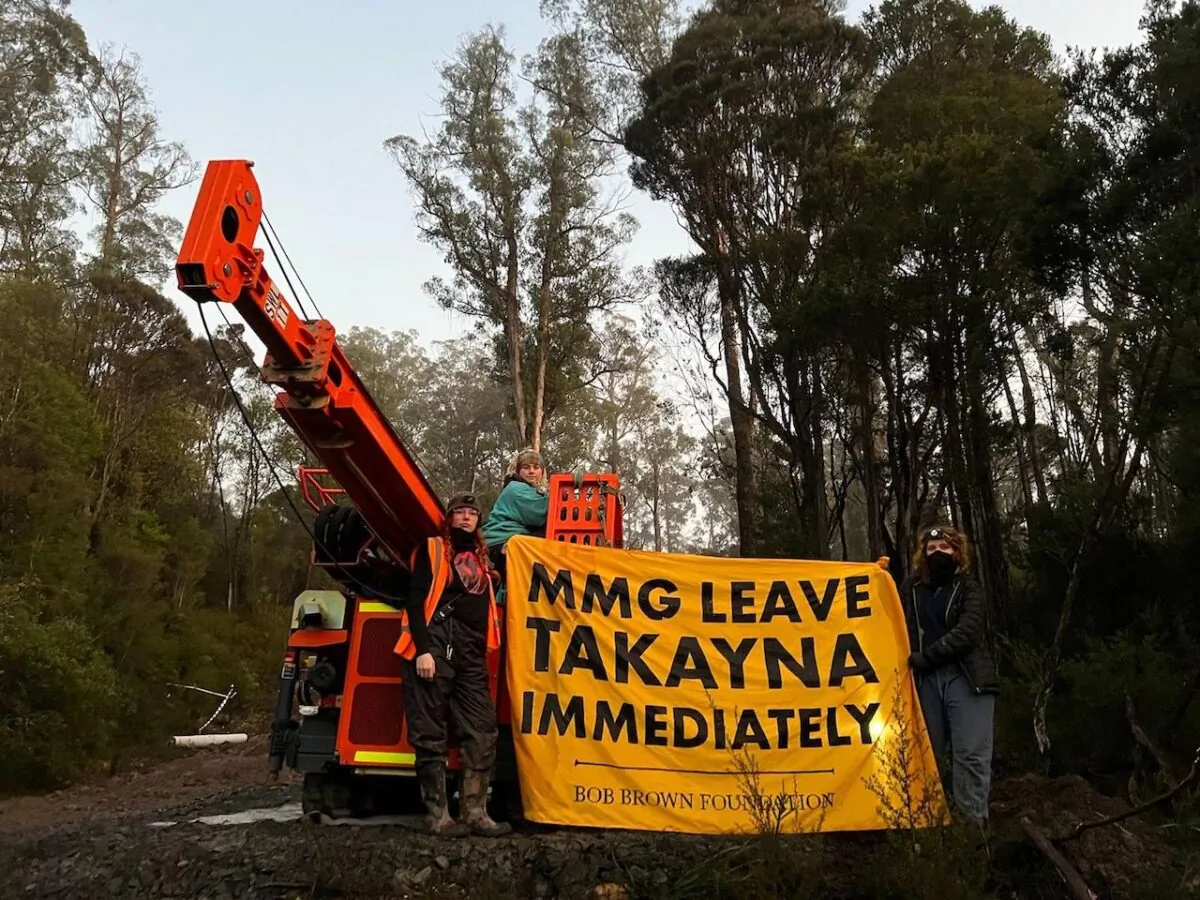 Protestors hold a sign campaigning against the proposed tailings dam mine near the Tarkine rainforest in Tasmania, Australia, on July 7, 2022. (Courtesy of Bob Brown Foundation)