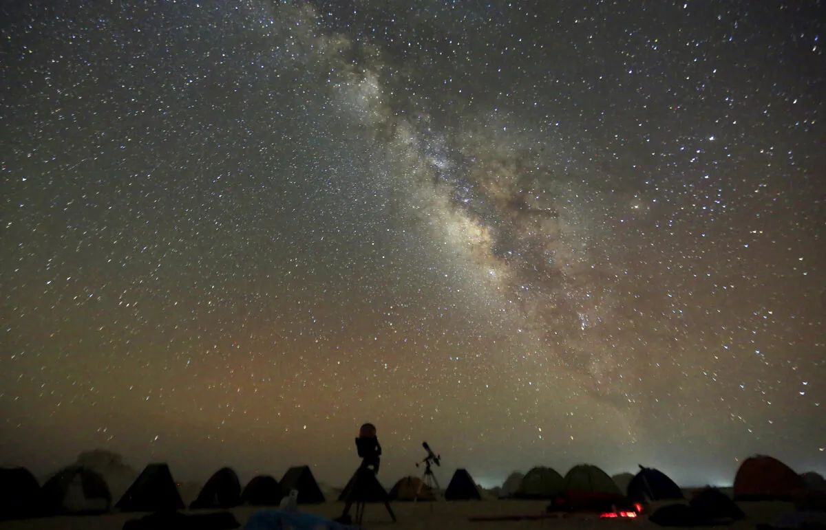 The Milky Way is seen in the night sky around telescopes and camps of people over rocks in the White Desert north of the Farafra Oasis southwest of Cairo on May 16, 2015. (Amr Abdallah Dalsh/Reuters)