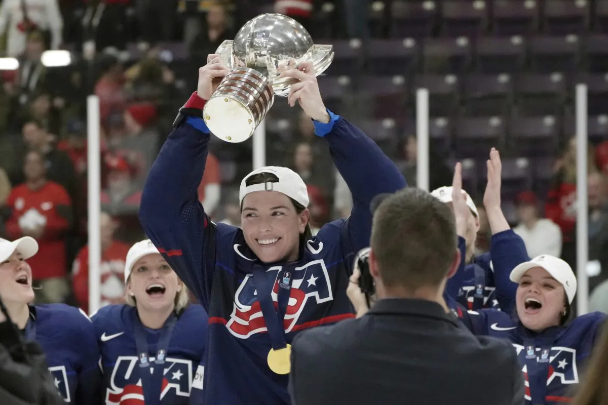 United States forward Hilary Knight (21) holds the cup as she celebrates with teammates after beating Canada in the gold medal game at the women's world hockey championships in Brampton, Ontario on April 16, 2023. (Nathan Denette/The Canadian Press via AP)