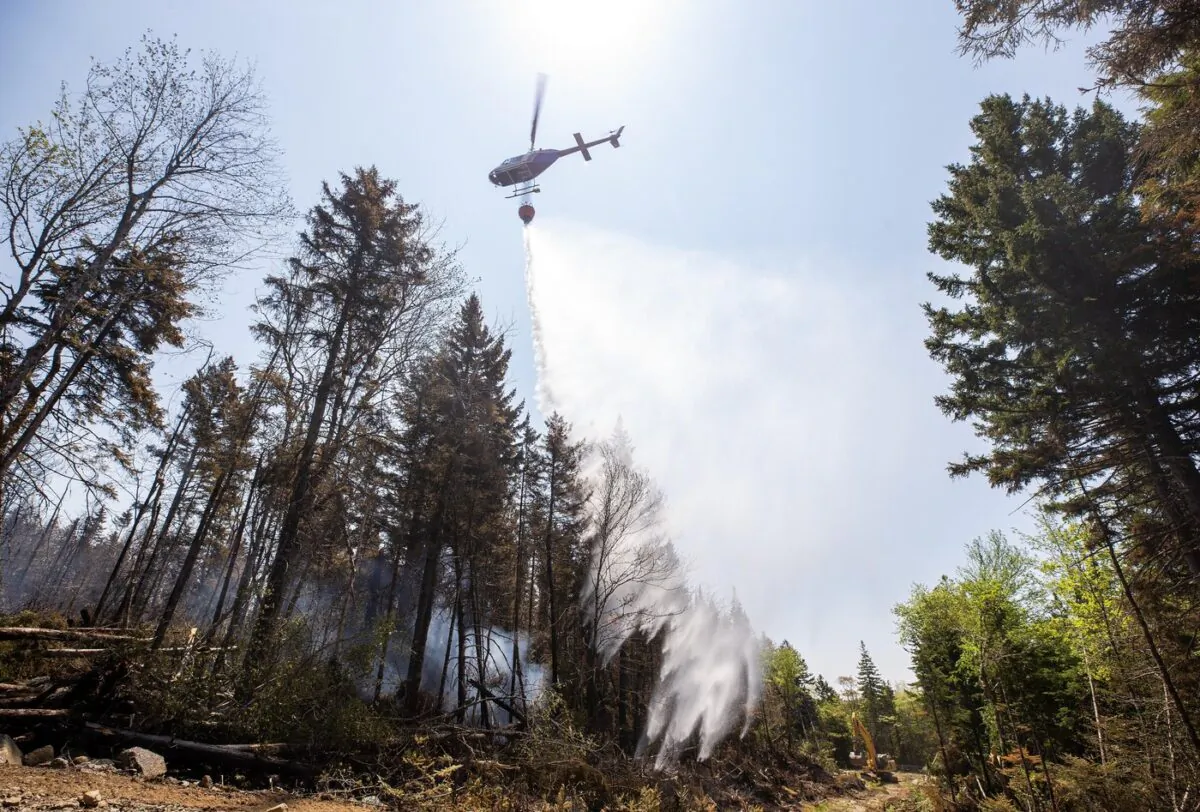 A helicopter drops water on a hot spot at a wildfire in Tantallon, N.S. on June 1, 2023. (THE CANADIAN PRESS/HO-Communications Nova Scotia)