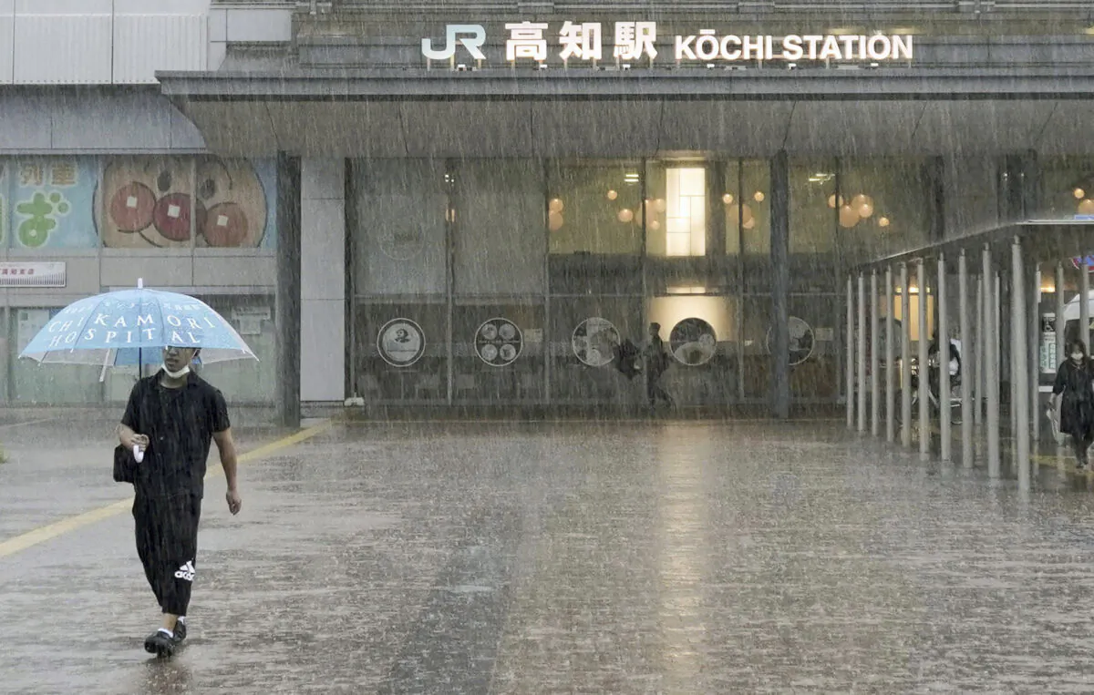 A person walks in a strong rain in Kochi, southern Japan, on June 2, 2023. (Kyodo News via AP)