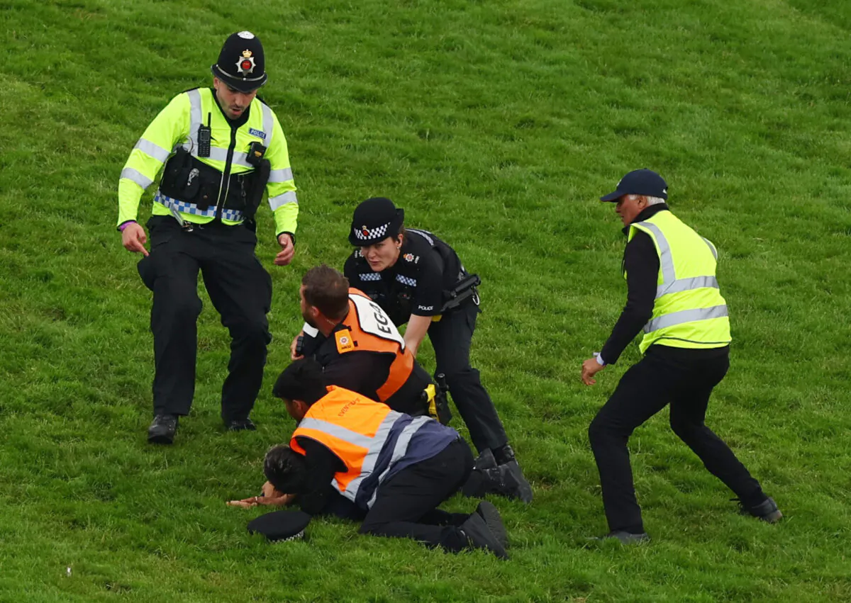 A protestor is removed from the race track by police officers during the 13:30 Betfred Derby Action at Epsom Downs Racecourse in Epsom, Britain, on June 3, 2023. (Matthew Childs/Images via Reuters)