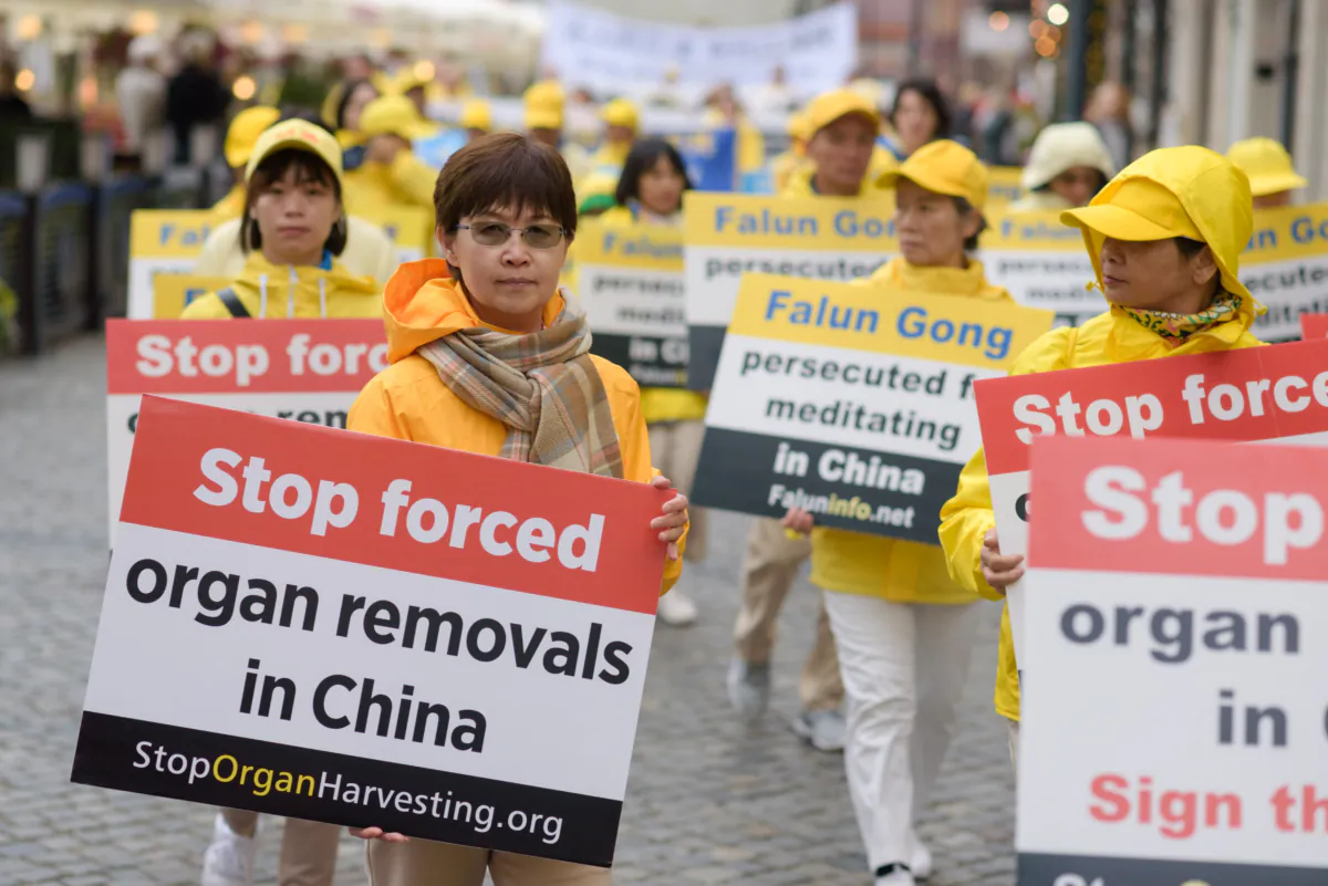Falun Gong practitioners carry banners to raise awareness about organ harvesting in China during a march through the center of Warsaw, Poland, on Sept. 9, 2022. (Mihut Savu/The Epoch Times)