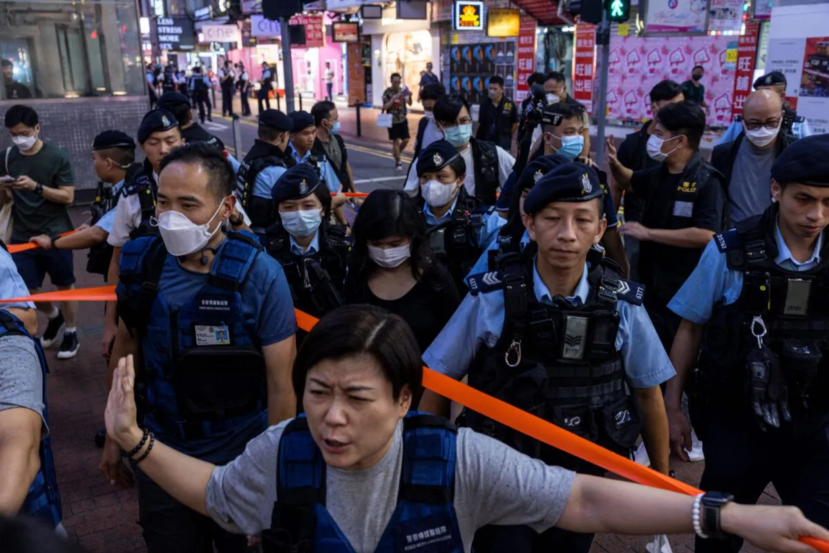 Police officers take away a member of the public in the Causeway Bay area in Hong Kong on June 3, 2023, on the eve of the 34th anniversary of the Tiananmen Square Massacre, which took place in China on June 4, 1989. (Louise Delmotte/AP Photo)