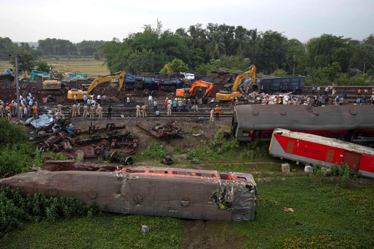 People watch at the site where trains that derailed, in Balasore district, in the eastern Indian state of Orissa on June 4, 2023. (Rafiq Maqbool/AP Photo)