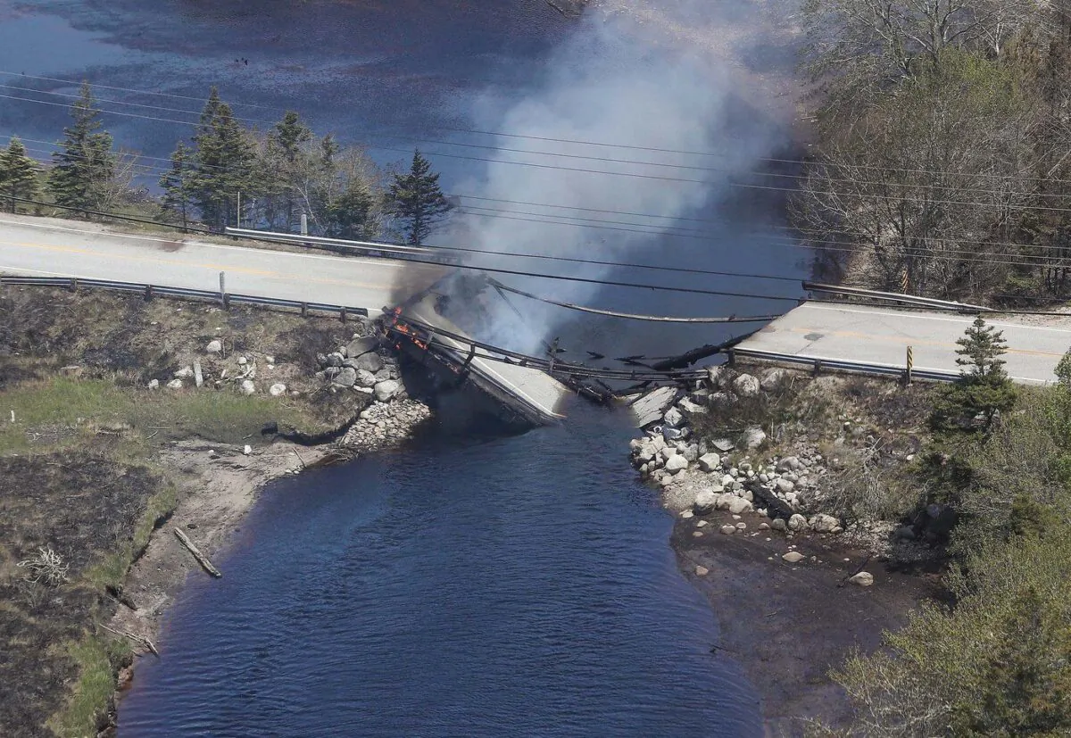 The collapsed bridge between the Clyde River and Port Clyde in Nova Scotia smoulders in this May 31, 2023 handout photo. (The Canadian Press/HO-Communications Nova Scotia)