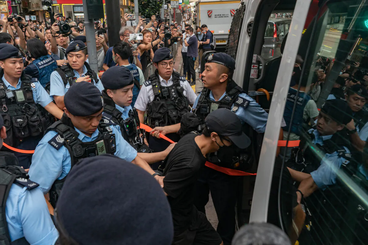 A man is detained by police officers at Causeway Bay near Victoria Park in Hong Kong on June 4, 2023. (Anthony Kwan/Getty Images)