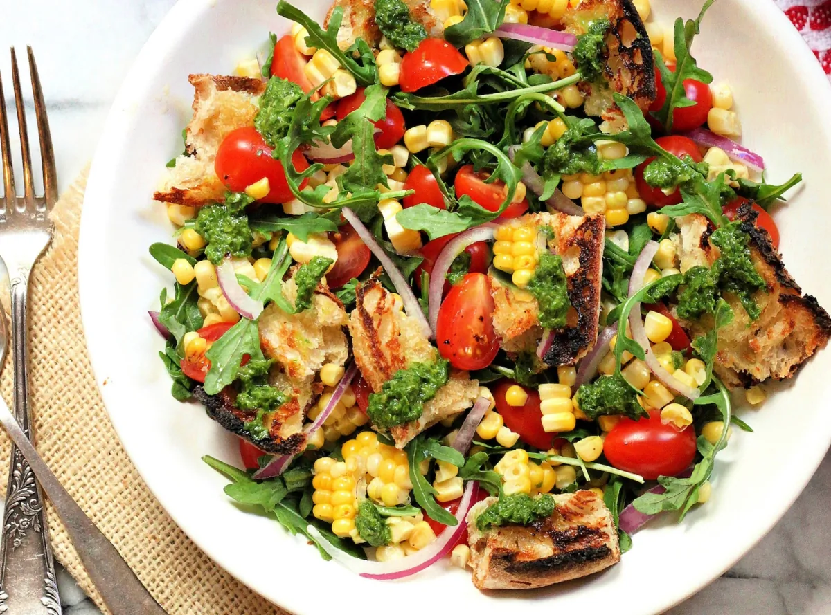Exuberantly ripe tomatoes, juicy sweet corn, quick-pickled red onions, and grilled bread come together in this summery mix. (Lynda Balslev for Tastefood)