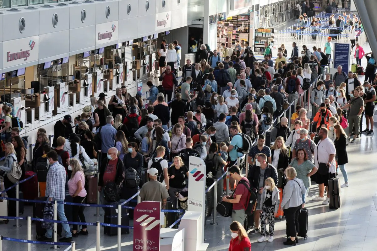 Passengers queue at Duesseldorf Airport during a warning strike staged by Lufthansa ground staff, on July 27, 2022. (Wolfgang Rattay/Reuters)